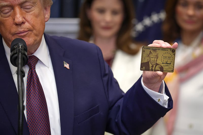President Donald Trump holds a "Trump Gold Card" during an event in the White House on December 19, 2025 in Washington, D.C.