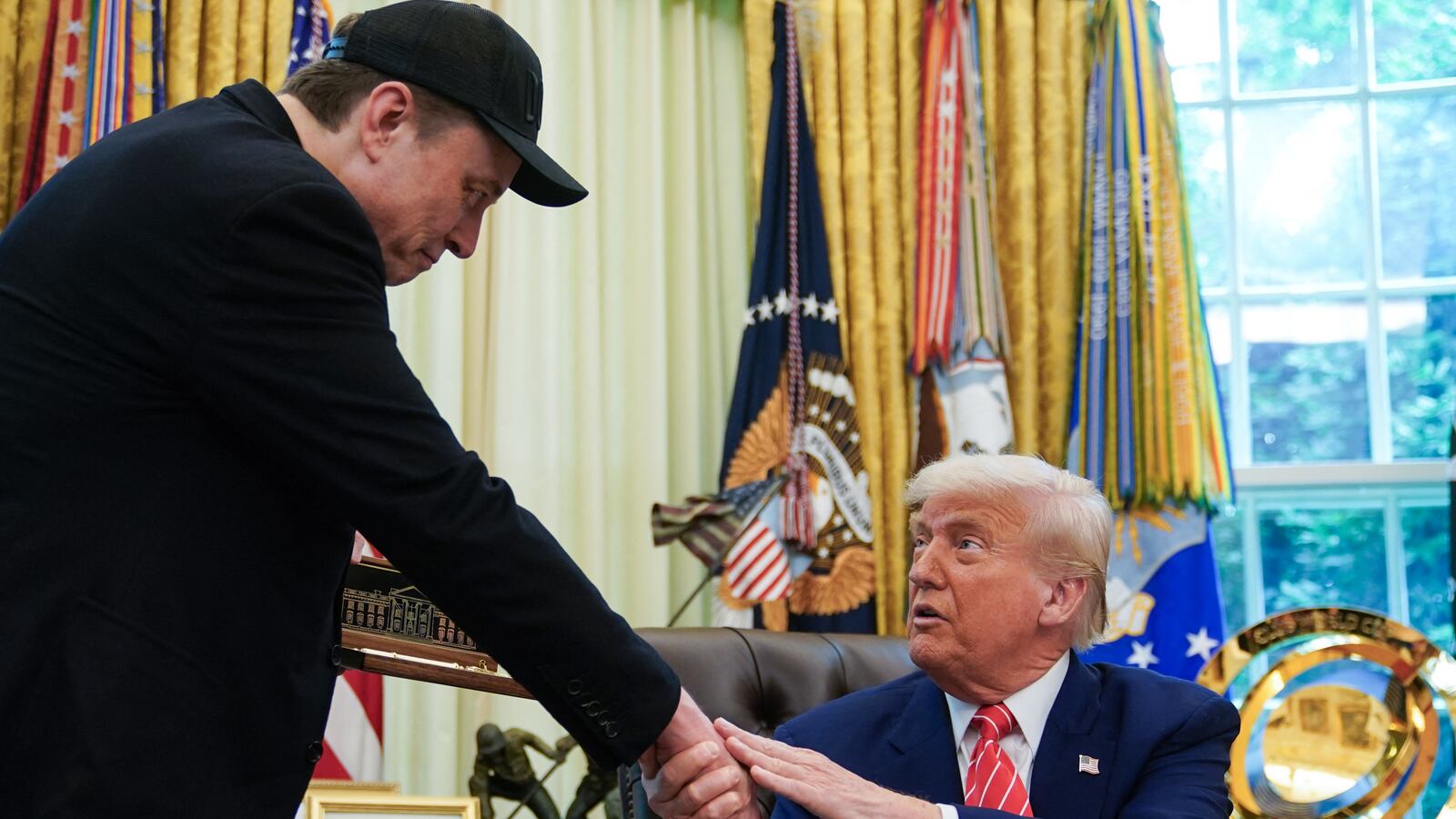 President Donald Trump shakes hands with Elon Musk after Trump gifted him with a “key to the White House” during a news conference in the Oval Office of the White House in Washington, DC, on May 30, 2025.