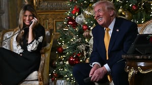 US President Donald Trump and first lady Melania Trump participate in NORAD Santa tracker phone calls, on Christmas Eve, from the Mar-a-lago club in Palm Beach, Florida, on December 24, 2025. (Photo by ANDREW CABALLERO-REYNOLDS / AFP)