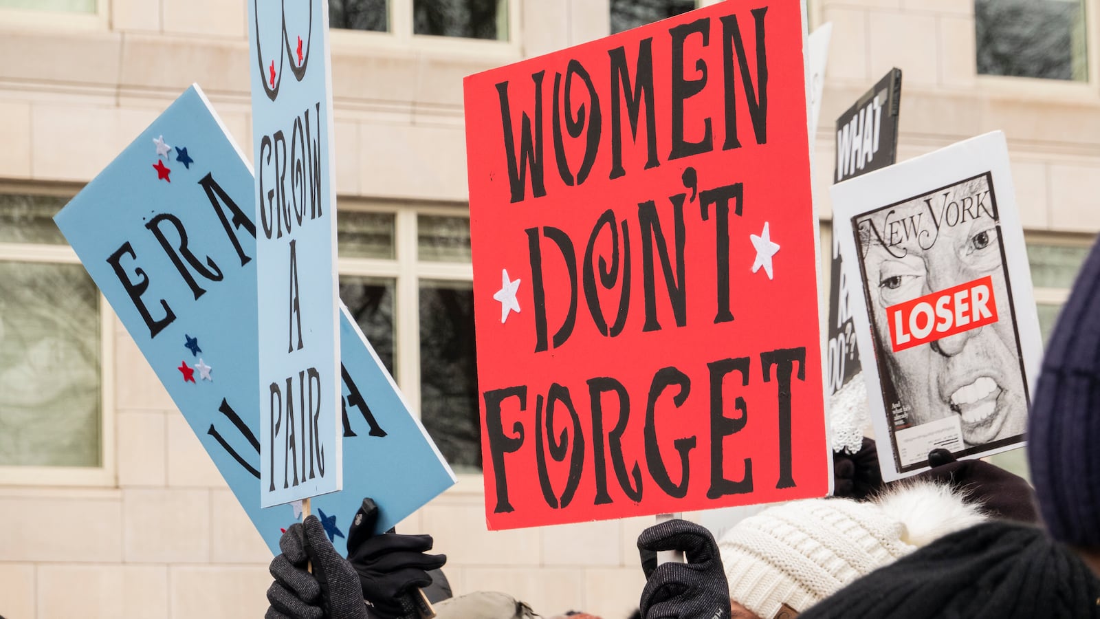 A sign reads “Women Don’t Forget” at a Women’s March gathering in 2020.