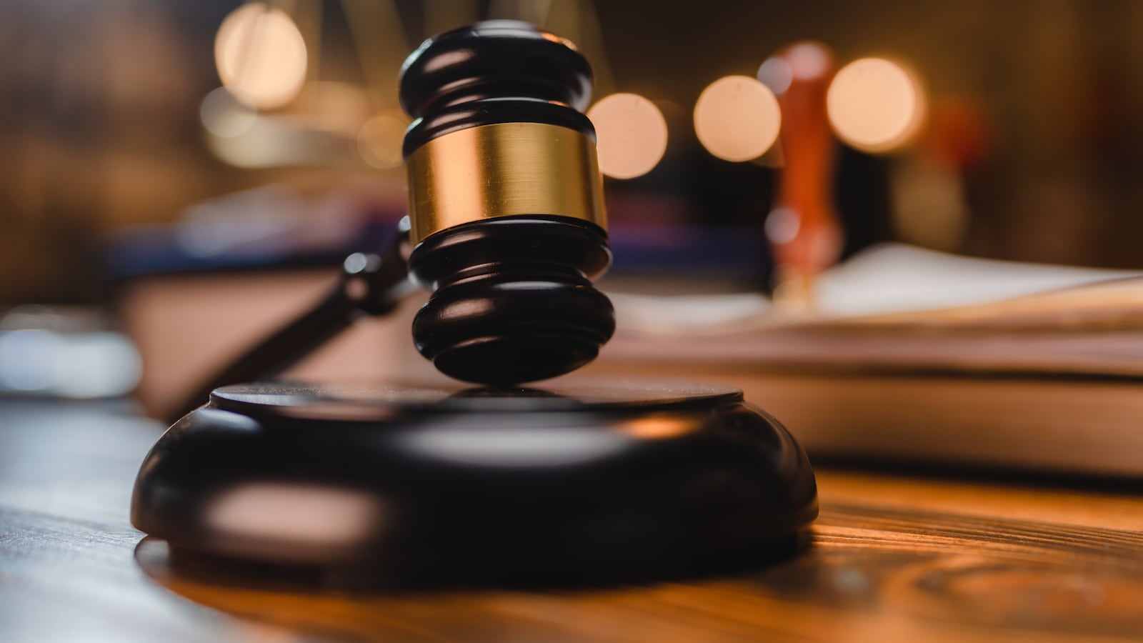 A judge’s gavel rests on a desk.