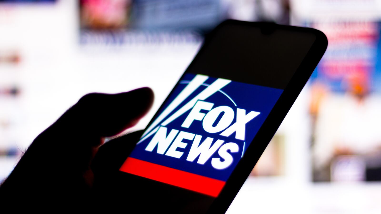 A photo illustration of the Fox News Channel logo seen displayed on a smartphone.