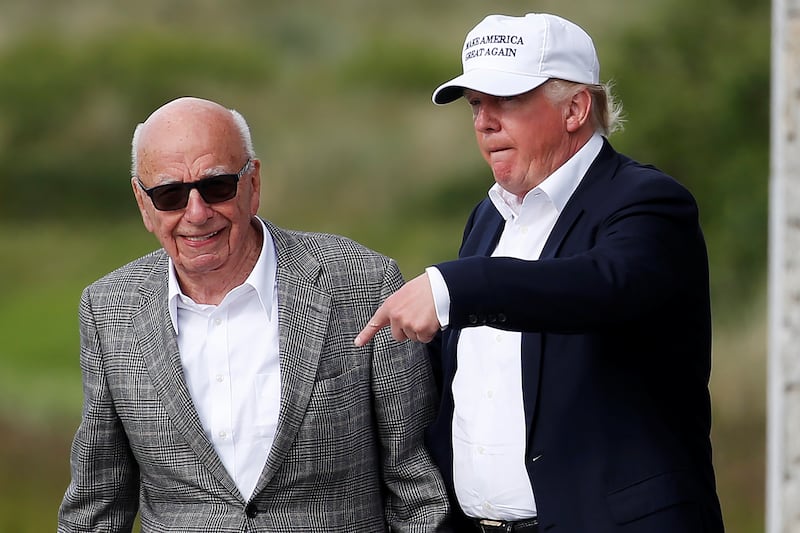 Republican presidential candidate Donald Trump (R) speaks to media mogul Rupert Murdoch as they walk out of Trump International Golf Links in Aberdeen, Scotland, June 25, 2016.  REUTERS/Carlo Allegri