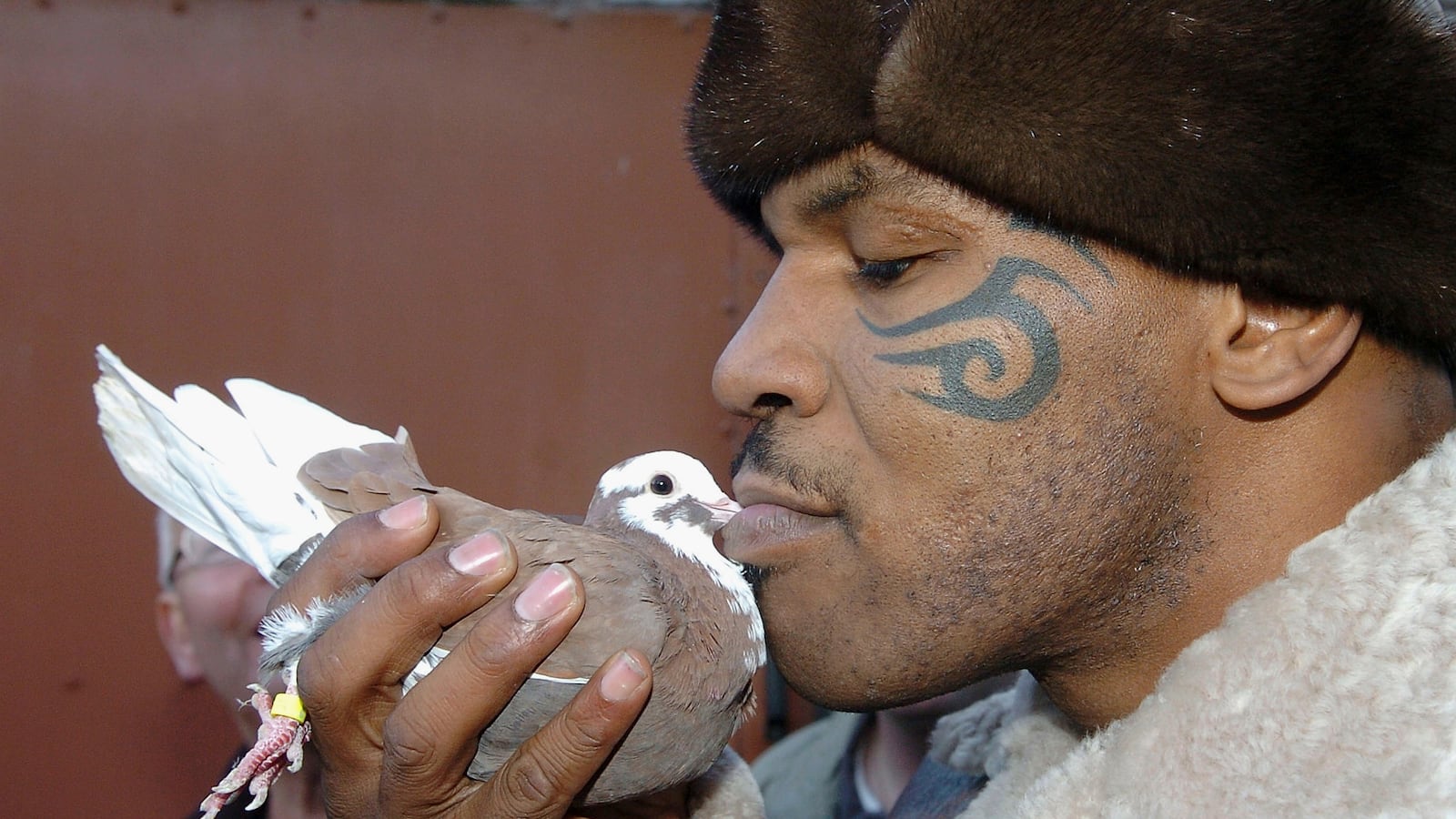 Mike Tyson kissing a pigeon.