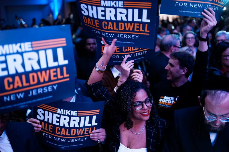 Supporters wave signs at the election night watch party for New Jersey Democratic gubernatorial candidate, Rep. Mikie Sherrill in East Brunswick, New Jersey while celebrating her victory.