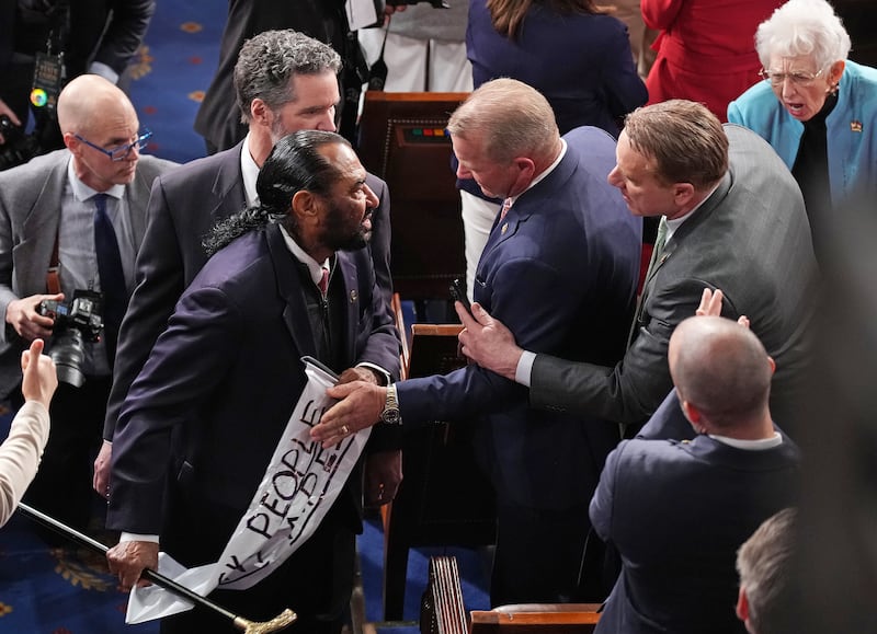 Troy Nehls (R-TX ) grabs a sign from ejected Rep. Al Green (D-TX)  as Trump delivers his State of the Union address during a Joint Session of Congress at the U.S. Capitol on Feb. 24, 2026, in Washington, DC. Trump delivered his address days after the Supreme Court struck down the administration's tariff strategy and amid a U.S. military buildup in the Persian Gulf threatening Iran.