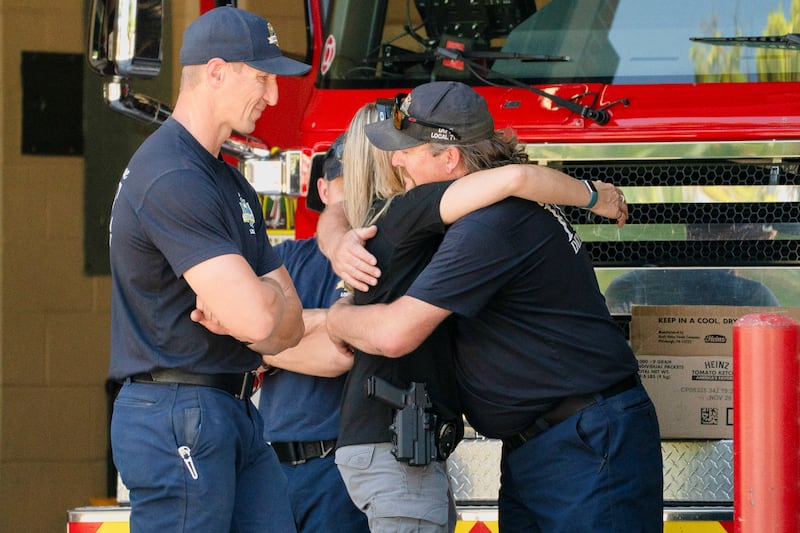 A Coeur d’Alene police officer hugs a Coeur d’Alene firefighter at a fire station a day after two firefighters were shot dead while responding to a fire and the body of a man was later found with a gun nearby in the Canfield Mountain area outside Coeur d’Alene, Idaho, U.S. June 30, 2025.  REUTERS/David Ryder