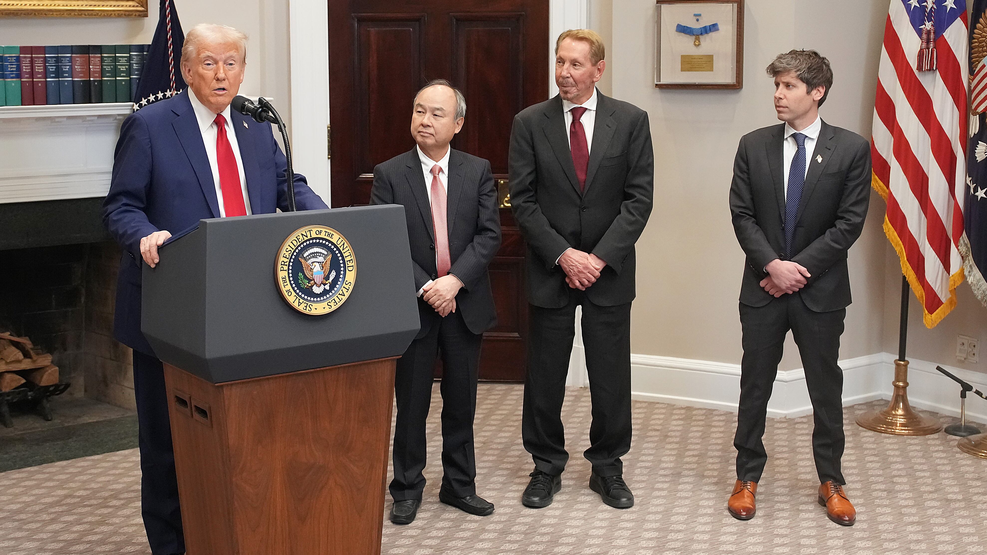 President Donald Trump speaks in the Roosevelt Room of the White House while SoftBank CEO Masayoshi Son, Oracle CTO Larry Ellison, and OpenAI CEO Sam Altman look on.