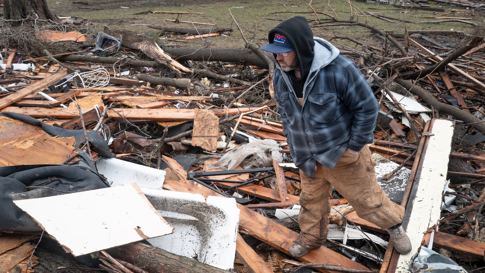 AROMA PARK, ILLINOIS - MARCH 11: Nick Cronin looks at a bathtub, which is still covered by debris, where his mother was found and rescued after her home was destroyed by yesterday's tornado on March 11, 2026 in Aroma Park, Illinois. Several tornadoes passed through Indiana and Illinois yesterday, leaving behind a path of destruction and at least two people dead in Lake Village, Indiana. (Photo by Scott Olson/Getty Images)