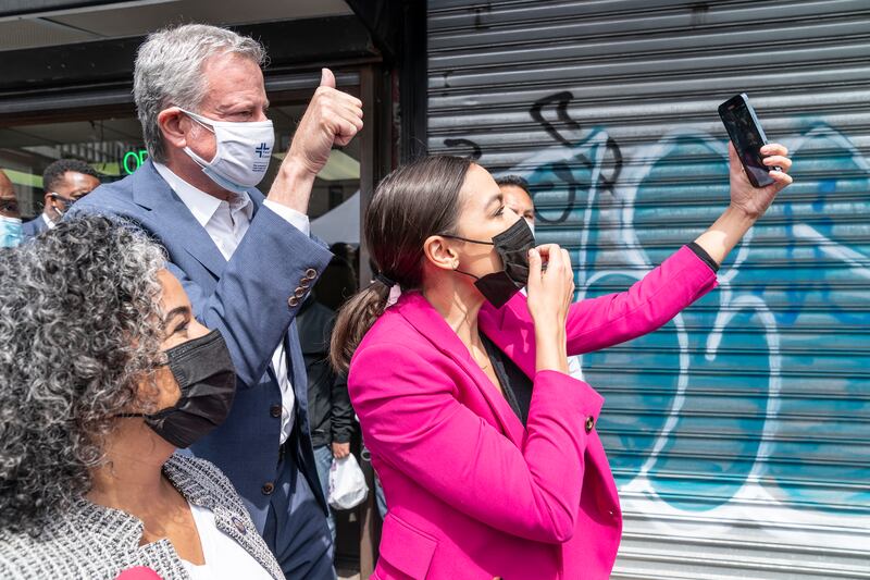 NEW YORK, UNITED STATES - 2021/05/07: Assemblywoman Karines Reyes, U. S. Representative Alexandria Ocasio-Cortez and mayor Bill de Blasio make selfie recording during visit to mobile vaccine bus on Castle Hill Avenue in the Bronx . People can get vaccinated inside the bus operated by Centers Urgent Care. The bus will serve mostly areas of the city where vaccination rate is lower than in more affluent neighborhoods and where there is more hesitancy to get vaccination. (Photo by Lev Radin/Pacific Press/LightRocket via Getty Images)