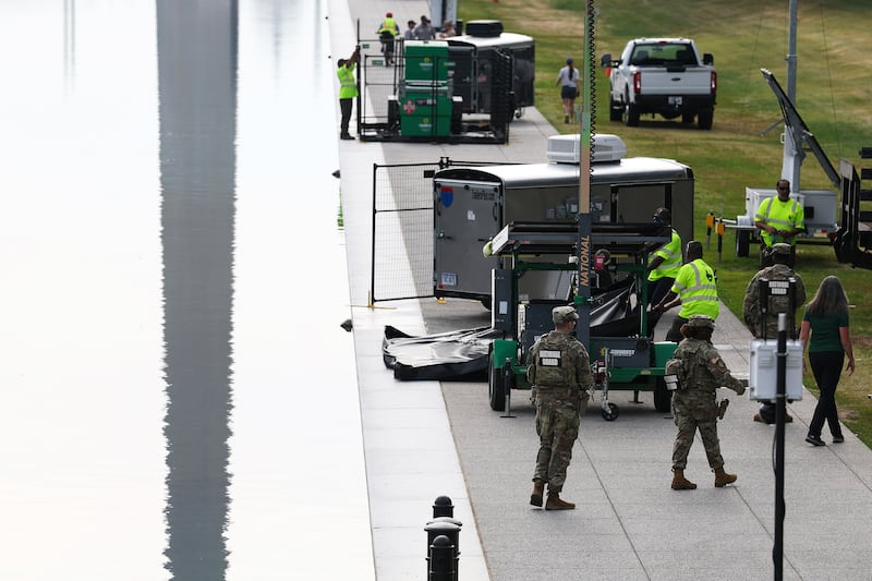 Members of the National Guard look on as National Park Service employees continue work on the Lincoln Memorial Reflecting Pool on the National Mall on June 25, 2026 in Washington, DC. Workers continue to clean algae from the reflecting pool amid an increased law enforcement presence after claims made by President Trump that vandalism was the cause of the damage.