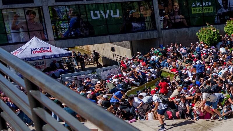 People run and crouch after right-wing activist and commentator Charlie Kirk was shot at a Utah Valley University speaking event in Orem, Utah, on Sept. 10, 2025.