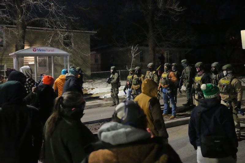 Protesters confront law enforcement at the scene of a reported shooting Wednesday, Jan. 14, 2026, in Minneapolis.