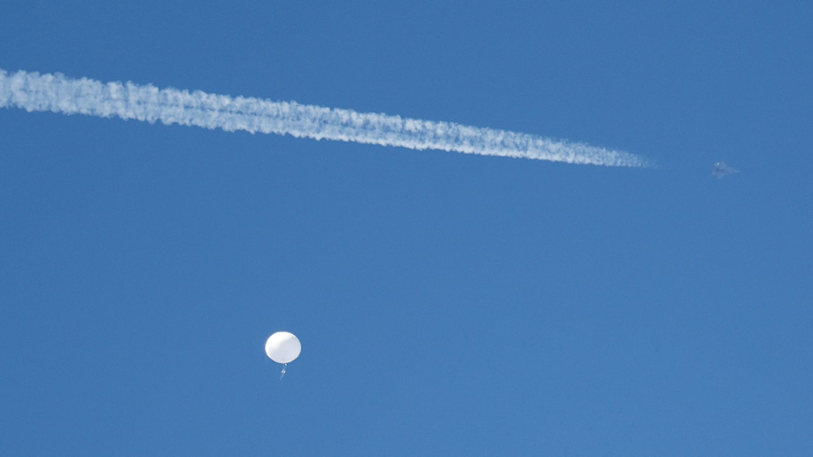 A jet flies by a suspected Chinese spy balloon as it floats off the coast in Surfside Beach, South Carolina, Feb. 4, 2023.