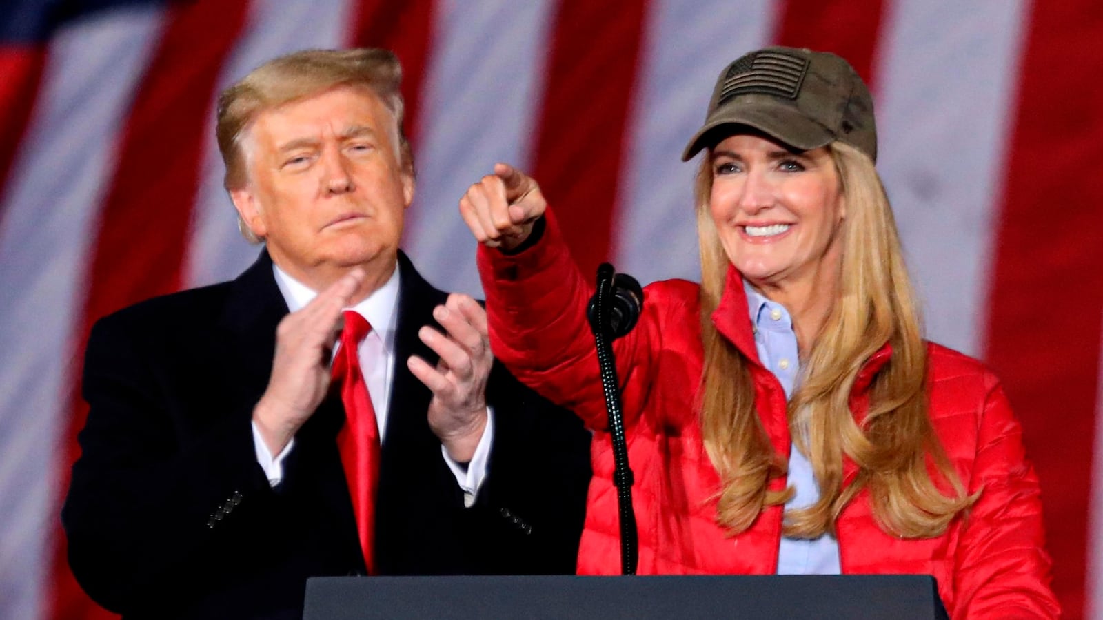 US President Donald Trump claps as Republican incumbent senator Kelly Loeffler speaks during a rally ahead of Senate the runoff in Dalton, Georgia on January 4, 2021. - President Donald Trump, still seeking ways to reverse his election defeat, and President-elect Joe Biden converge on Georgia on Monday for dueling rallies on the eve of runoff votes that will decide control of the US Senate. Trump, a day after the release of a bombshell recording in which he pressures Georgia officials to overturn his November 3 election loss in the southern state, is to hold a rally in the northwest city of Dalton in support of Republican incumbent senators Kelly Loeffler and David Perdue. (Photo by SANDY HUFFAKER / AFP) (Photo by SANDY HUFFAKER/AFP via Getty Images)