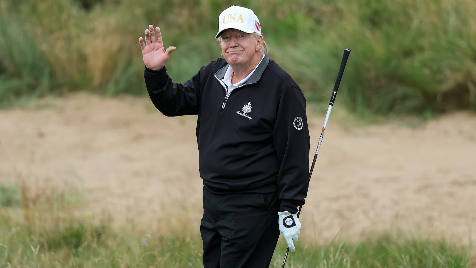 President Donald Trump holds a driver after teeing off during the opening of his new golf course at his Trump International Golf links resort on July 29, 2025 in Balmedie, Scotland. President Trump is visiting Scotland in a trip that’s part-vacation, part-work, as he stayed at his Trump Turnberry golf course, followed by Trump International Golf Links in Aberdeenshire, between July 25 to 29.
