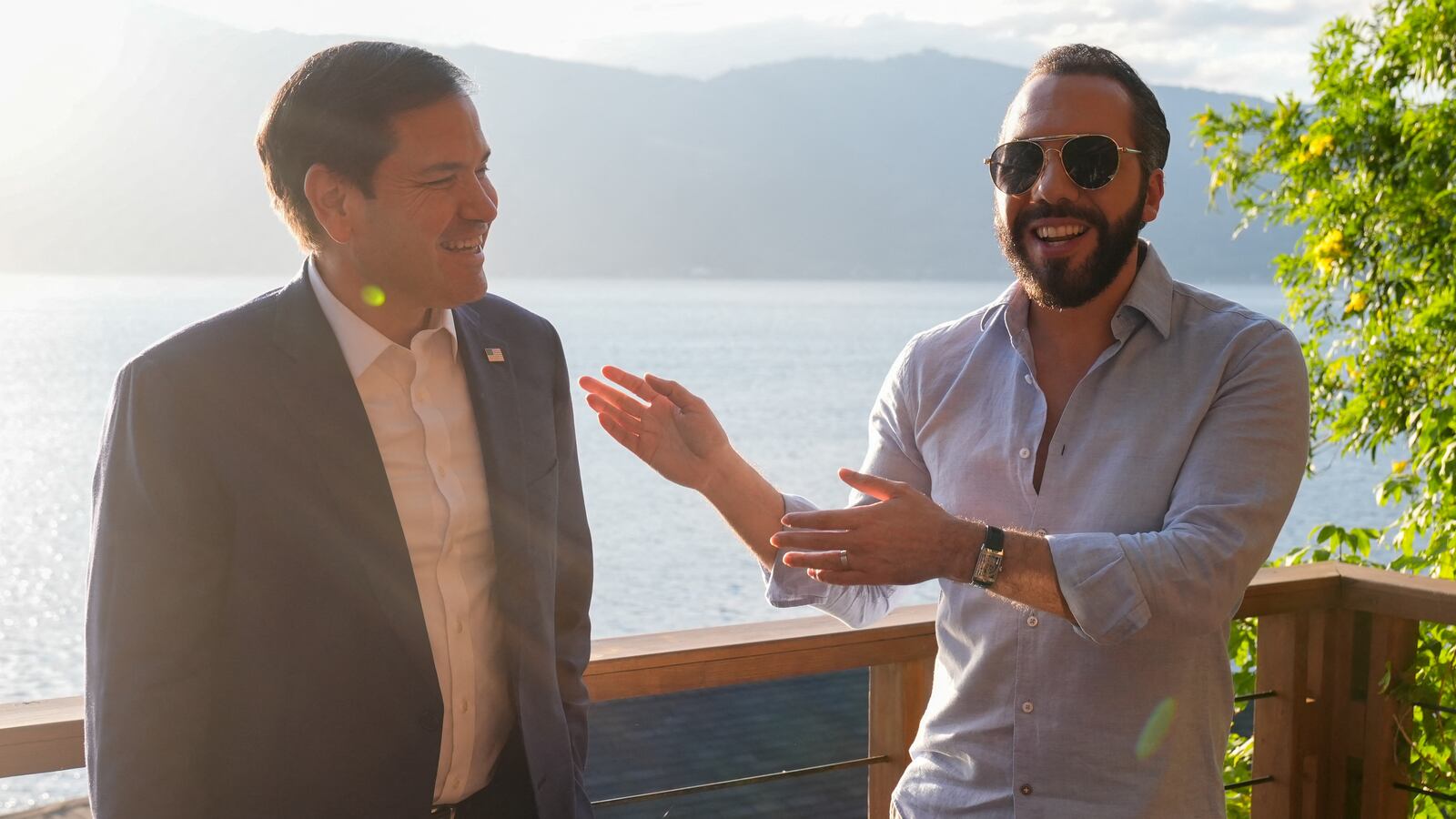 Marco Rubio on the left and El Salvador's President Nayib Bukele on the right, standing in front of a lake in El Salvador