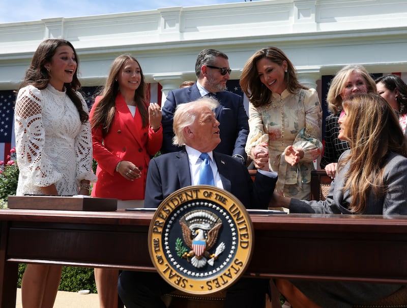 President Donald Trump and Rep. Maria Salazar clasp hands during the signing ceremony for the Take It Down Act in April 2025.