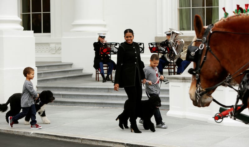 First lady Michelle Obama, and her nephews Aaron with first dog Bo, and Austin with first dog Sunny, walk out to greet the White House Christmas tree at the North Portico in Washington, U.S. November 25, 2016.  REUTERS/Gary Cameron