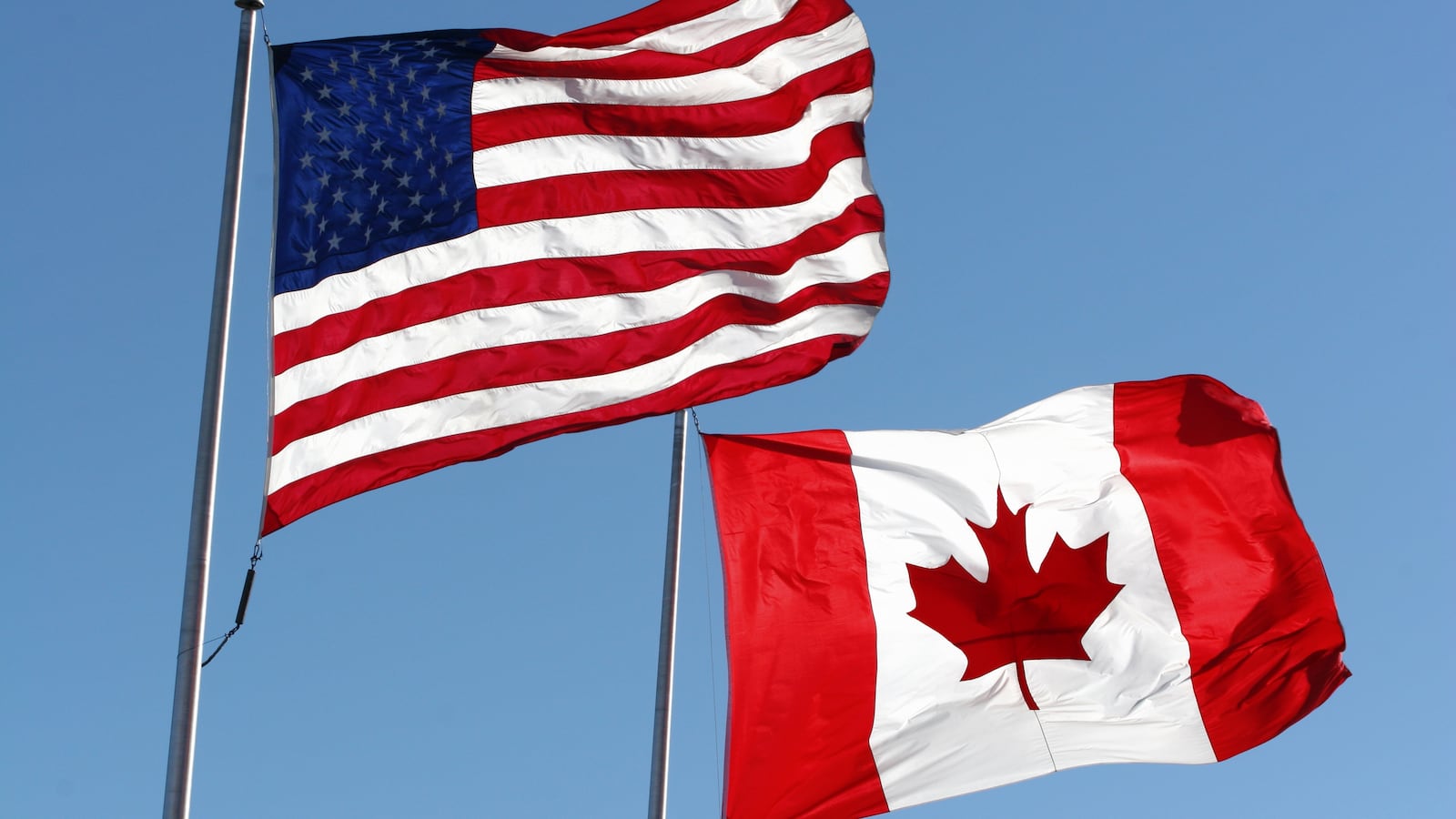 An American & Canadian flag waving in the wind.