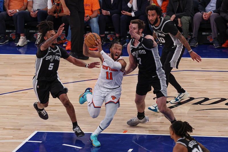 New York Knicks guard Jalen Brunson (11) drives to the basket against San Antonio Spurs guard Stephon Castle (5) and center Luke Kornet (7) during game three of the 2026 NBA Finals at Madison Square Garden