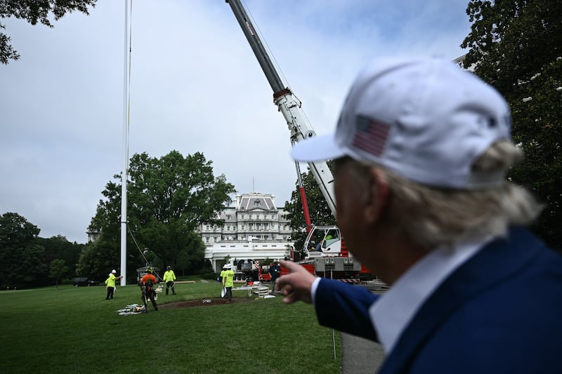 US President Donald Trump speaks to the press as workers install a large flag pole on the South Lawn of the White House in Washington, DC on June 18, 2025. President Trump left the question of whether the United States will join Israeli strikes on Iran up in the air Wednesday, as he said that Tehran had reached out to seek negotiations. "I may do it, I may not do it. I mean, nobody knows what I'm going to do," Trump told reporters as he supervised the installation of a new flagpole on the White House South Lawn.