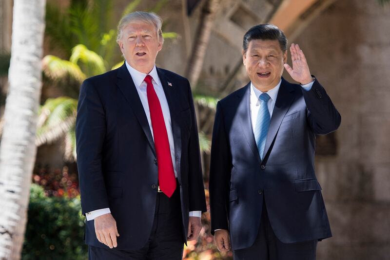 TOPSHOT - Chinese President Xi Jinping (R) waves to the press as he walks with US President Donald Trump at the Mar-a-Lago estate in West Palm Beach, Florida, April 7, 2017. (Photo by JIM WATSON / AFP) (Photo by JIM WATSON/AFP via Getty Images)