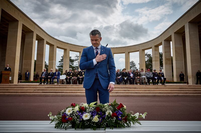 Secretary of Defence Pete Hegseth gestures as he lays a wreath during a ceremony at the Normandy American Cemetery