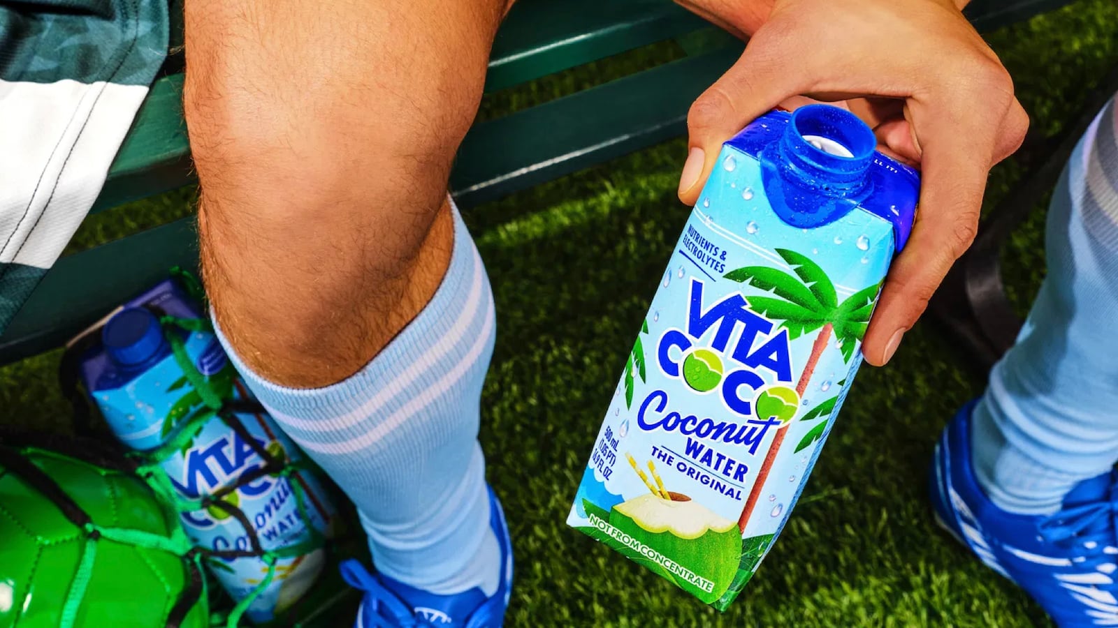 Man holding a bottle of Vita Coco coconut water