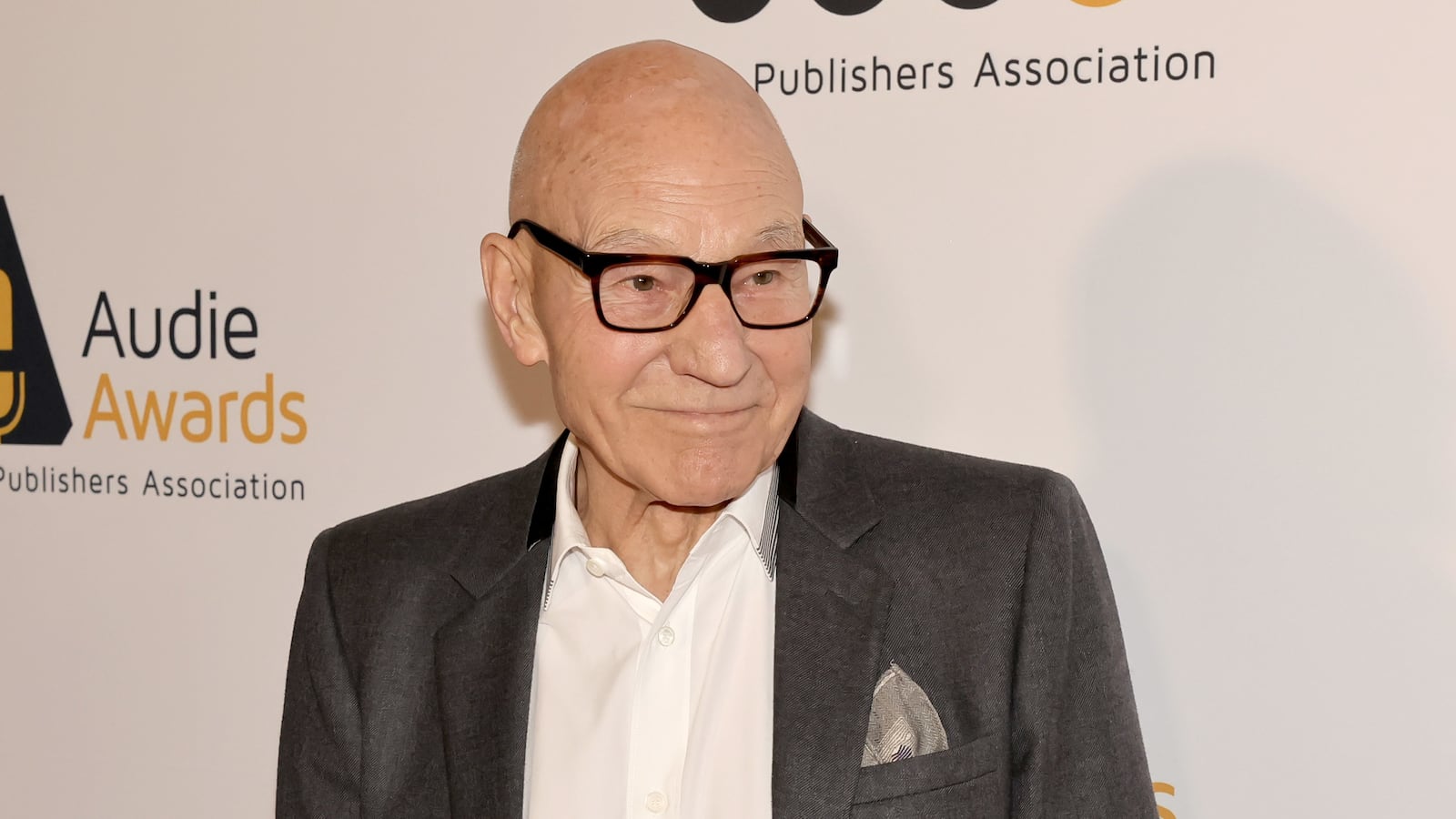 Patrick Stewart poses for photos at an event.