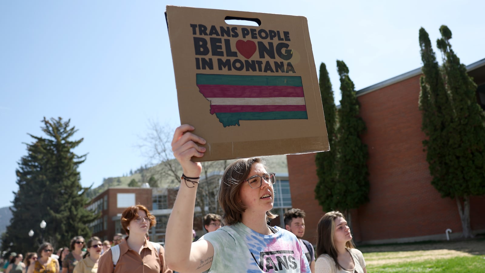 Transgender rights activists hold signs as they march through the University of Montana campus