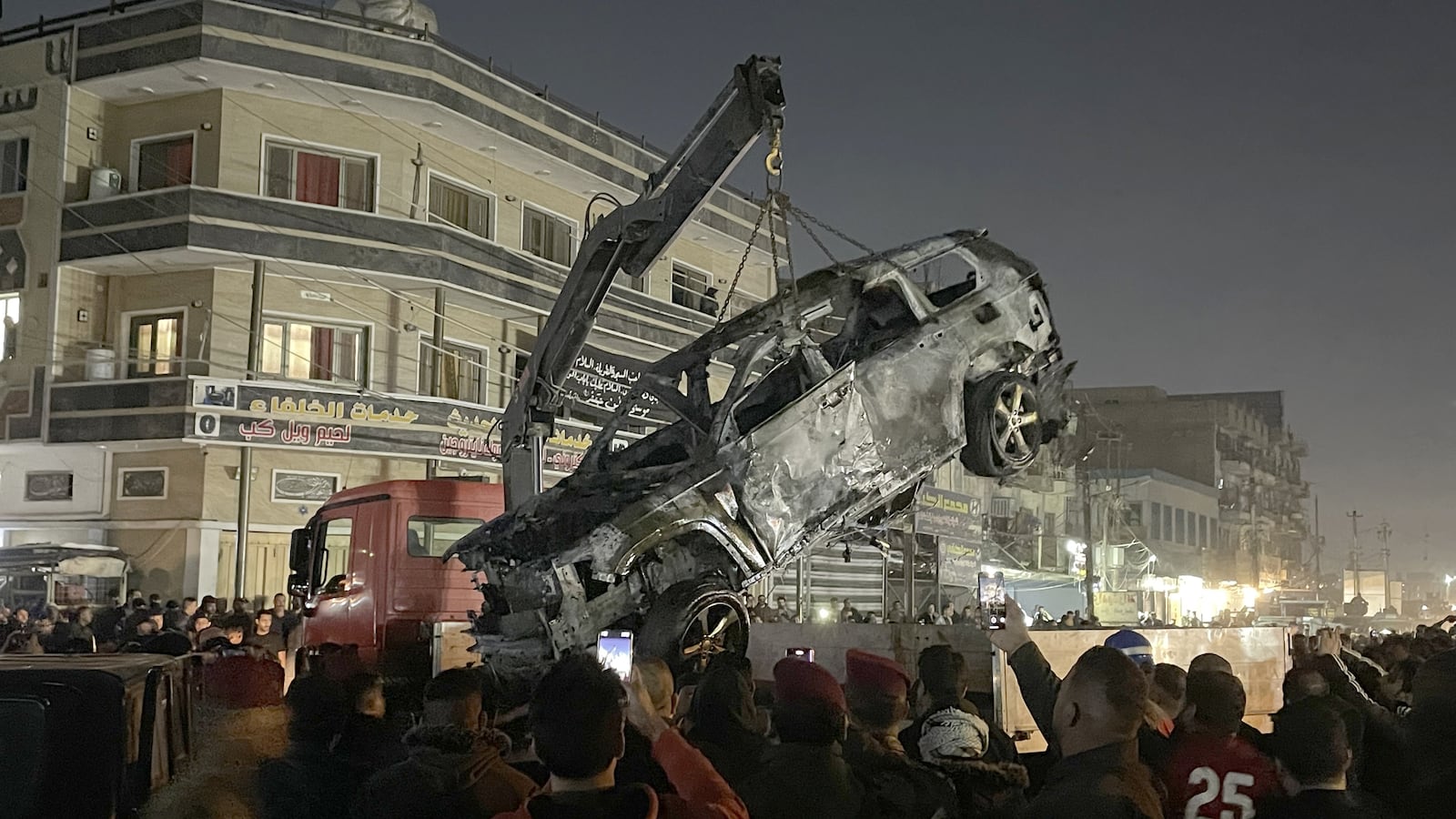 A crane lifts the wrecked car which has been targeted to kill the Senior commander Abu Baqir al-Saadi of Popular Mobilization Forces (Al-Hashd al-Shaabi) at eastern area of Al-Mashtal in Baghdad