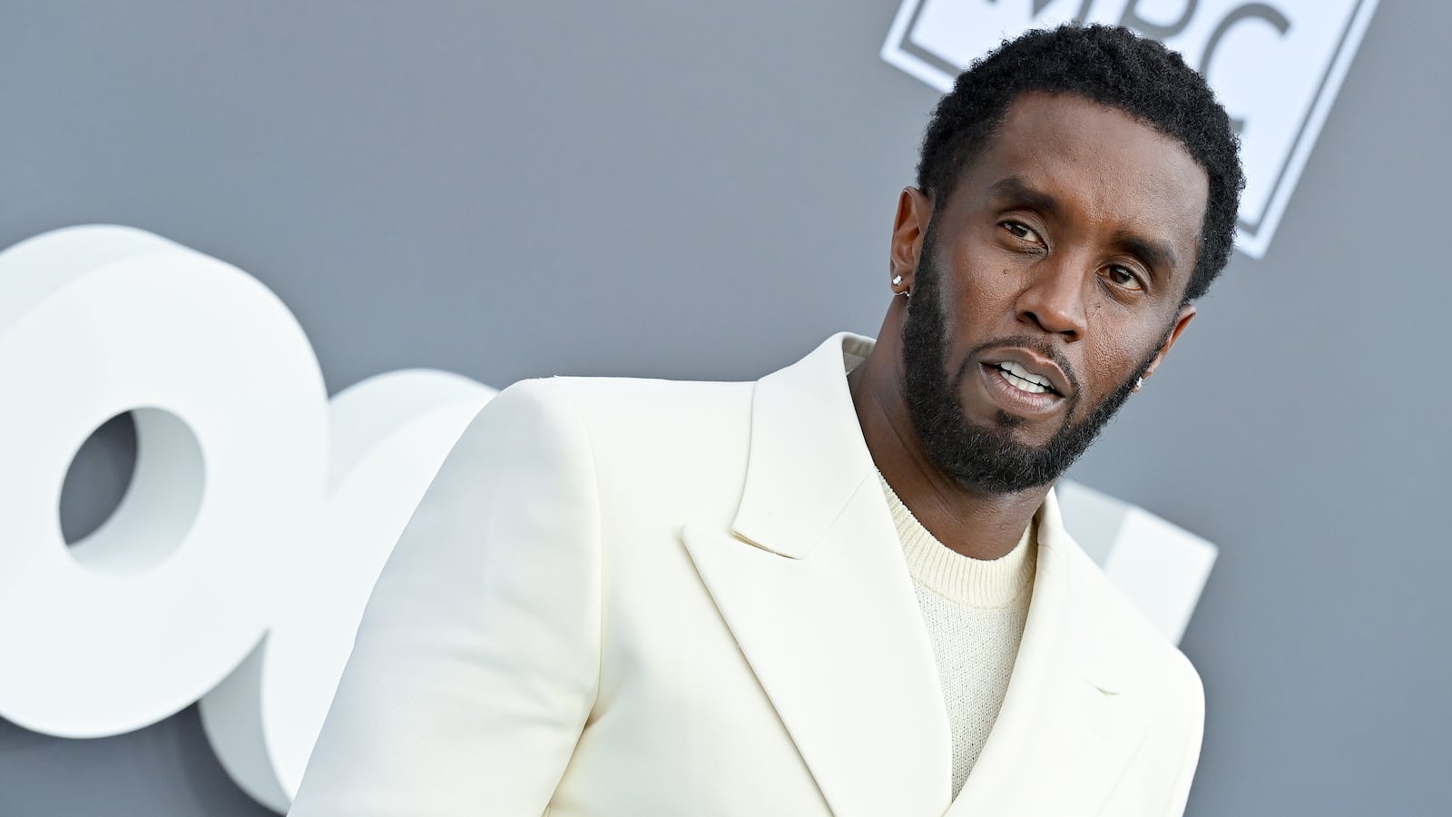 Sean “Diddy” Combs poses in a white suit.