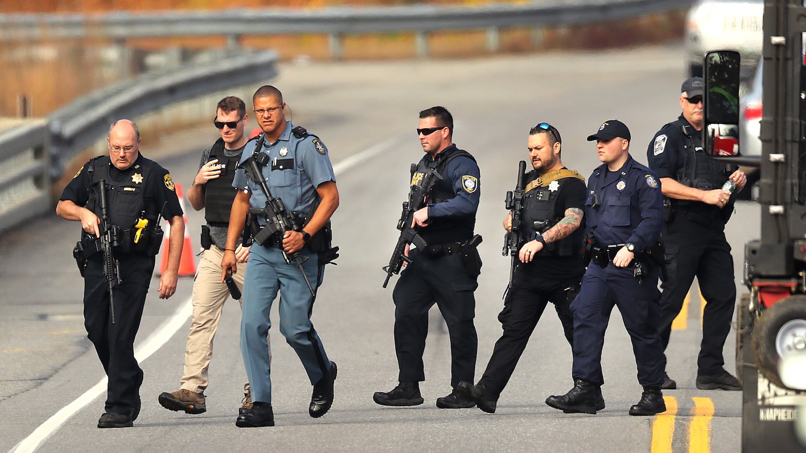 Heavily armed police walk near near the boat launch in the Androscoggin River on Rt 196 where suspect Robert Card abandoned his car.