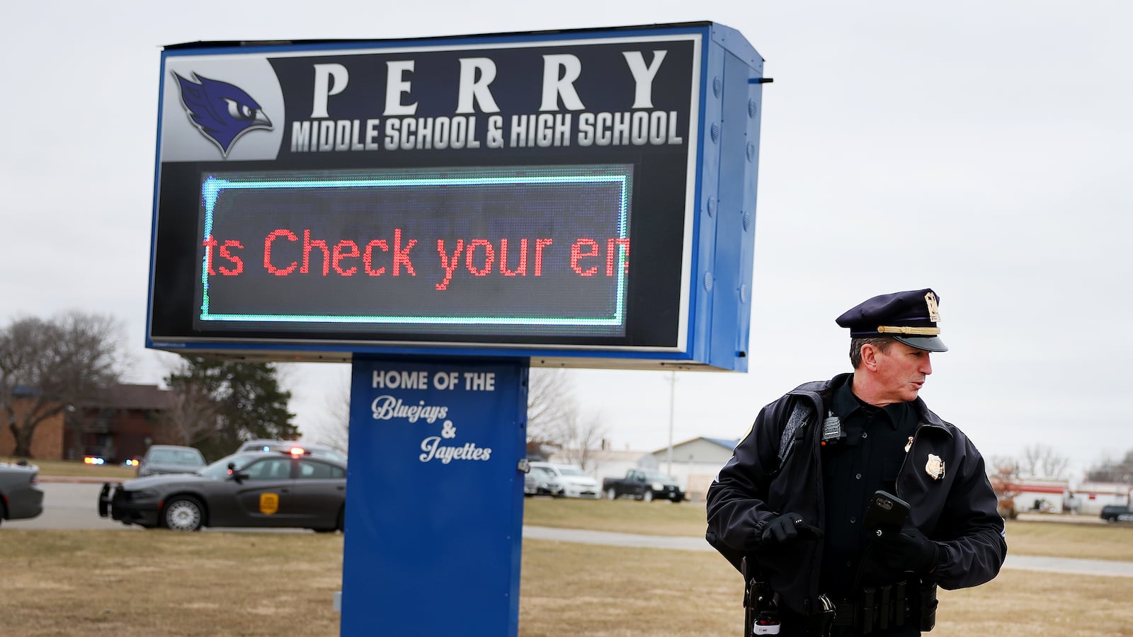 A police officer stands guard outside the Perry Middle School and High School complex following a school shooting on January 4 in Perry, Iowa.