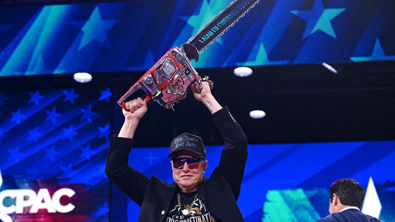 Elon Musk holds a chainsaw reading "Long live freedom, damn it" during the annual Conservative Political Action Conference (CPAC) at the Gaylord National Resort & Convention Center at National Harbor in Oxon Hill, Maryland, on Feb. 20, 2025. The chainsaw was a present to Elon Musk from Argentina's President Javier Milei. (Photo by SAUL LOEB / AFP) (Photo by SAUL LOEB/AFP via Getty Images)