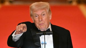 Donald Trump points at camera while speaking at a lecture.