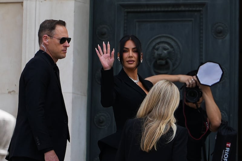 Kim Kardashian waves at the fans and arrives at the Palais de Justice, on May 13, 2025 in Paris, France.