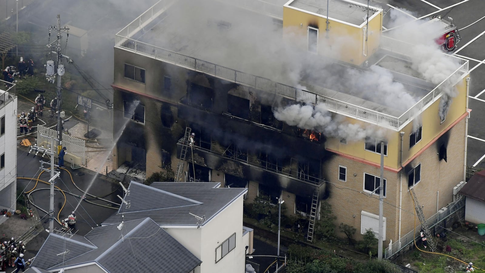 An aerial view shows firefighters battling fires at the site where a man started a fire after spraying a liquid at a three-story studio of Kyoto Animation Co. in Kyoto, western Japan, in this photo taken by Kyodo, July 18, 2019.