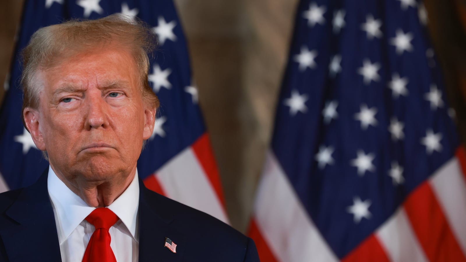 Republican presidential candidate former President Donald Trump speaks in front of American flags at Mar-a-Lago.