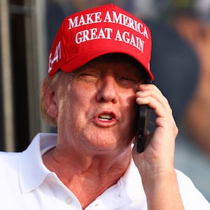 Former U.S. President Donald Trump speaks on the phone at the 18th green during day three of the LIV Golf Invitational - Miami at Trump National Doral Miami on April 07, 2024 in Doral, Florida.
