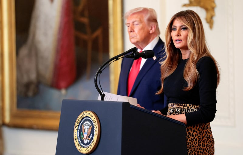 Donald Trump listens as first lady Melania Trump speaks during a Women's History Month event.