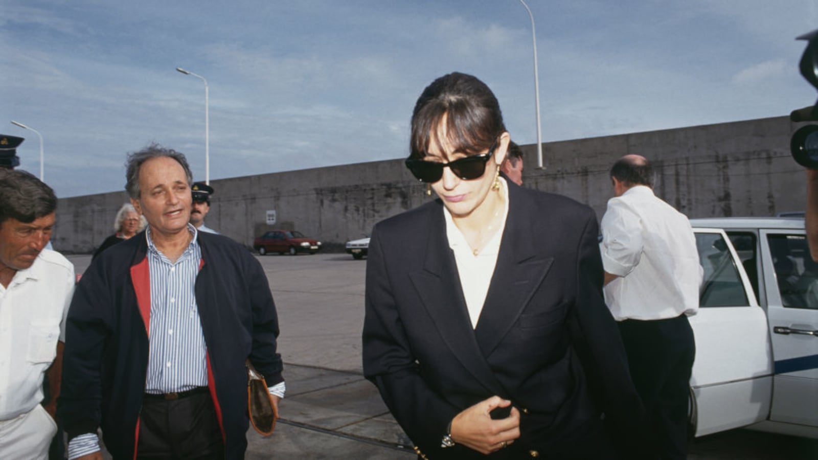 Jeffrey Epstein’s accomplice Ghislaine Maxwell walks away from a car in dark sunglasses.