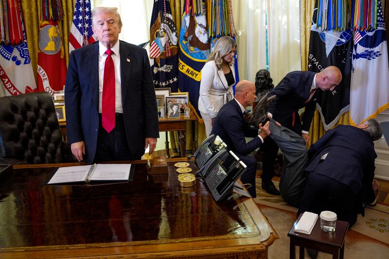 WASHINGTON, DC - NOVEMBER 06: (EDITOR'S NOTE: Alternate Crop) U.S. President Donald Trump stands by as attendees help a guest after he collapsed during during an event on lowering drug prices in the Oval Office at the White House on November 06, 2025 in Washington, DC. Trump announced that his administration has reached agreements with drugmakers Eli Lilly and Novo Nordisk that would lower the price of some GLP-1 weight loss medications. (Photo by Andrew Harnik/Getty Images)