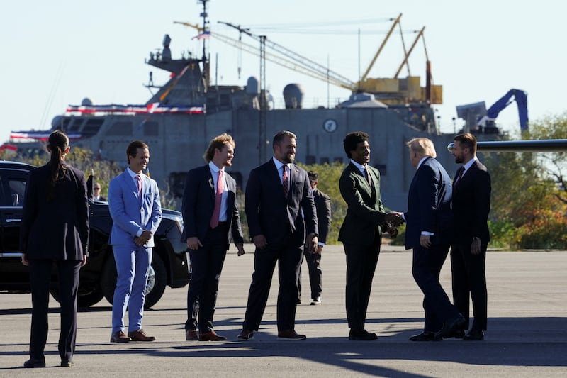 Trump greets Baltimore Ravens players Tyler Loop, Ryan Eckley, Nick Moore, and Marlon Humphrey after exiting Marine One to attend an event at Sparrows Point Shipyard in Baltimore County, Maryland.