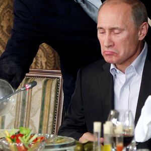 FILE PHOTO:    Evgeny Prigozhin (L) assists Russian Prime Minister Vladimir Putin during a dinner with foreign scholars and journalists at the restaurant Cheval Blanc on the premises of an equestrian complex outside Moscow November 11, 2011. Picture taken November 11.  REUTERS/Misha Japaridze/Pool/File Photo