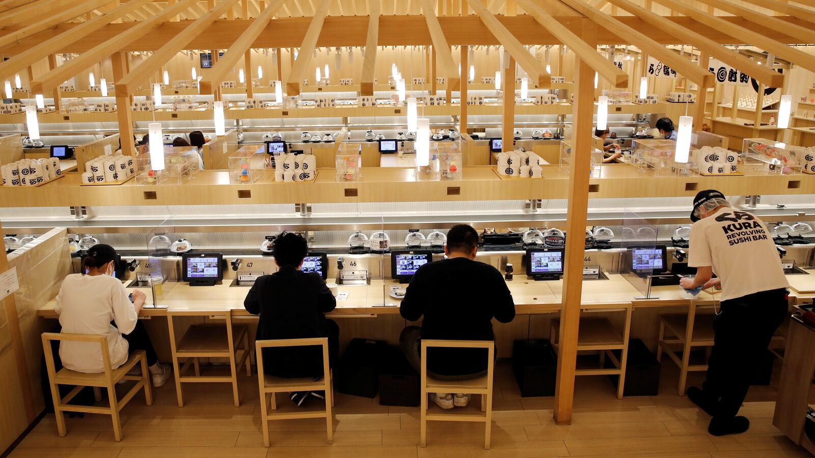 Customers eat sushi off a conveyor belt at a Kura Sushi restaurant in Tokyo, Japan, June 3, 2021.