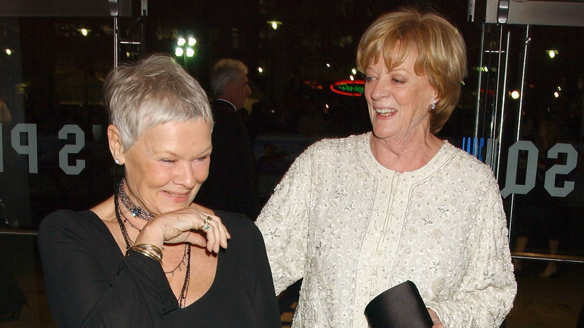Dame Judi Dench and Dame Maggie Smith share a laugh together in 2004