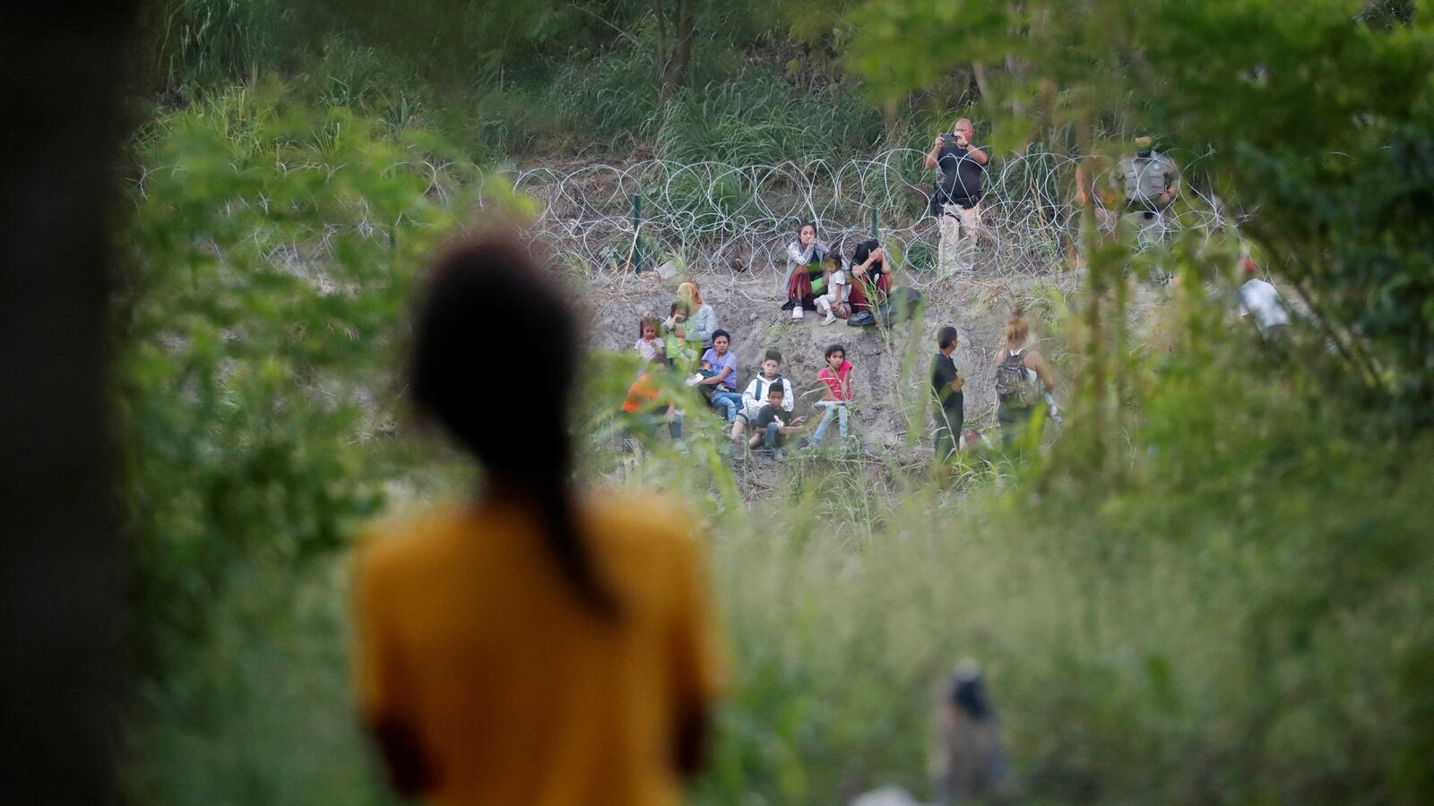 A group of migrants being turned back to Mexico by U.S. border patrol agents.