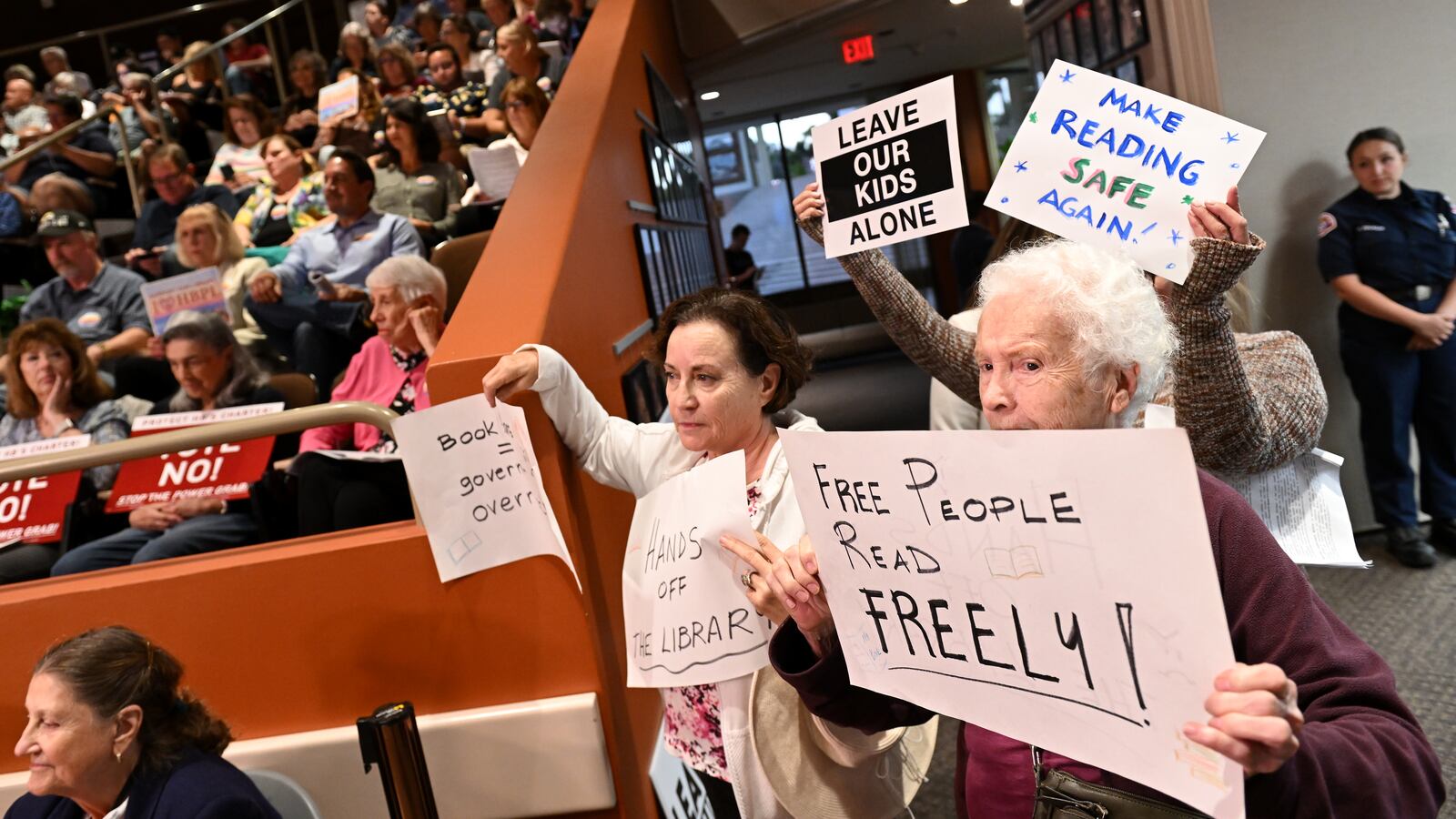 Opponents of a book ban hold signs